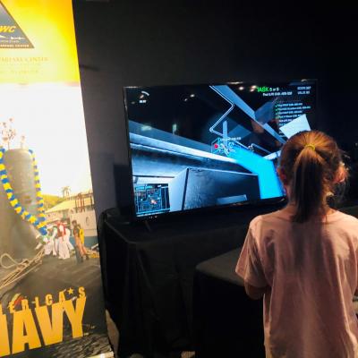 Girl interacts with NAWCTSD STEM display at an event in Orlando, Florida.