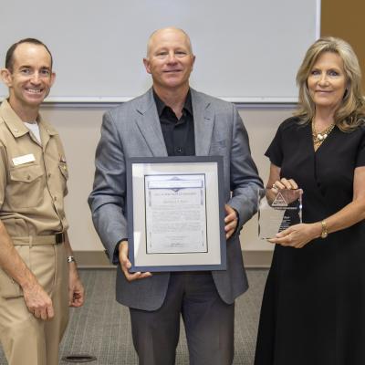 Rear Adm. Scott Dillon, left, NAWCWD commander, and Joan Johnson, right, NAWCWD executive director, pose with EEO Supervisor Award winner Rich Burr during the Honorary Awards Ceremony in Point Mugu, California, on June 27. (U.S. Navy photo by Rob Grabendike)