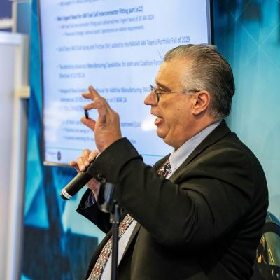 Theodore Gronda, program manager for the NAVAIR Additive Manufacturing (AM) Team, highlights ways AM has helped solve supply chain issues for the Navy at the Sea-Air-Space Expo 2024.