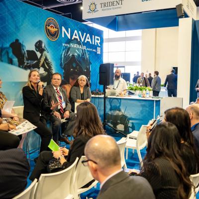 Members of the NAVAIR Office of Small Business Programs talk to attendees about partnering with NAVAIR at the 2024 Sea-Air-Space Expo.