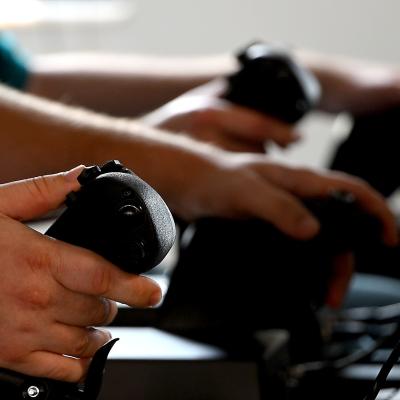 Engineers hold onto desktop aircraft controls during a demonstration.