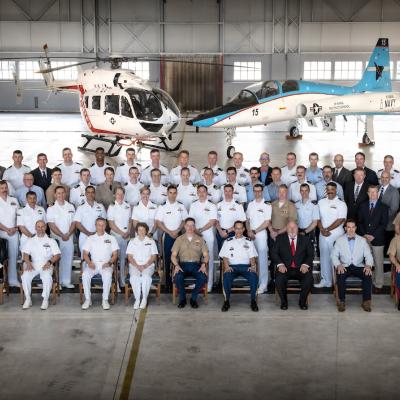 This photo shows a group shot of several graduates and Test Pilot School personnel in front of an aircraft.