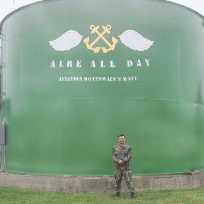 Aviation Boatswain's Mate Second Class Philip Ringgenberg stands by the water tower at Naval Air Warfare Center Aircraft Division Lakehurst