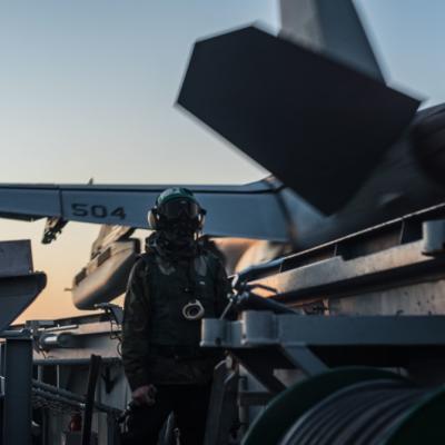 A sailor watches a catapult launch off the flight deck