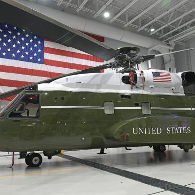 Helicopter in a hanger with the American flag behind it