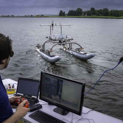 A man operates an unmanned system in the water with a game controller.