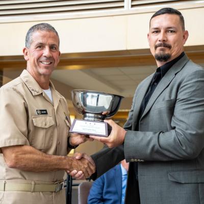 PMA-276’s Brian Evans accepts the 2022 NAVAIR Commander’s Award in the ‘Speed of Capability Delivery’ category from Vice Adm. Carl Chebi, commander, NAVAIR, on behalf of the Communications/Navigation team. 