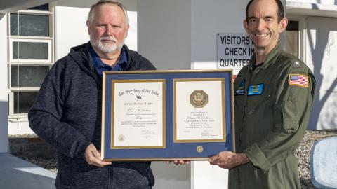 Clint Robbins poses with Rear Adm. Scott Dillon in front of the headquarters building in China Lake after receiving a 40-year length-of-service award on Jan. 6. (U.S. Navy photo by Ryan Smith)