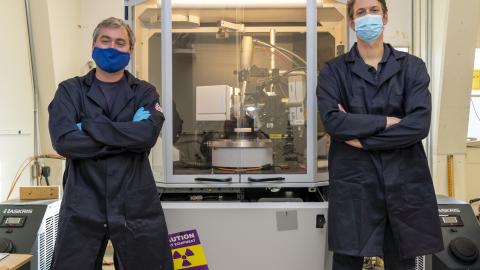 Dr. Randall McClain, left, and Dr. Ben Harvey stand in front of a single crystal X-ray diffractometer, which is used to determine the chemical structure of molecules. (U.S. Navy photo by Ryan Smith)