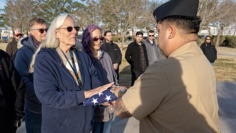 Surrounded by family and friends, Debbie Covey (left) is presented with a flag in honor of nearly 50 years of service to the government during a ceremony Jan.  28 in China Lake, Calif. (U.S. Navy photo by Ryan Smith) 