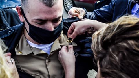 Chief Aviation Electronics Technician Joshua Coughlin receives his anchors from family members during a chief petty officer (CPO) pinning ceremony hosted by the U.S. Naval Test Pilot School at Naval Air Station Patuxent River on Jan. 29, 2021.