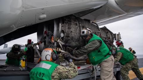 Strike Fighter Squadron (VFA) 147 load an F-35C engine module onto a CMV-22B Osprey with Fleet Logistics Multi-Mission Squadron (VRM) 30