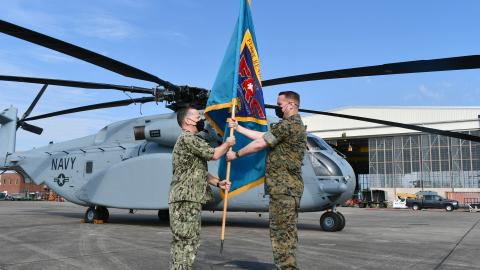 Outgoing Fleet Readiness Center East commander passes guidon to incoming commanding officer