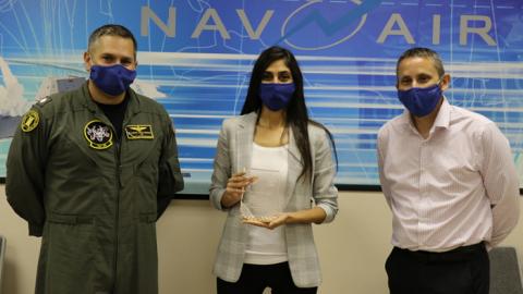 Manik Yeremyan, center, holds her Test Engineer of the Year Award, presented to her by Cmdr. Jason Saglimbene, VX-30 commanding officer, and Dan Toland, Weapons and Warfare Systems Test Department head, in a ceremony Oct. 7 in Point Mugu. (U.S. Navy photo by Kimberly Brown)