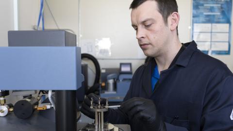 Michael Garrison, NAWCWD research chemist, loads a polymer sample for dynamic mechanical analysis. The technique allows researchers to measure the mechanical properties of polymers at different temperatures. (U.S. Navy photo by Scott Clarke)