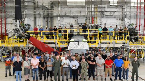 Group poses in front of V-22 aircraft