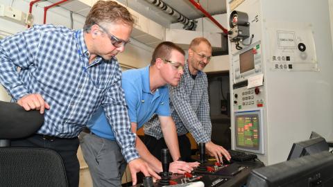 Three FRCE test equipment engineers observe software function on a jet engine test cell