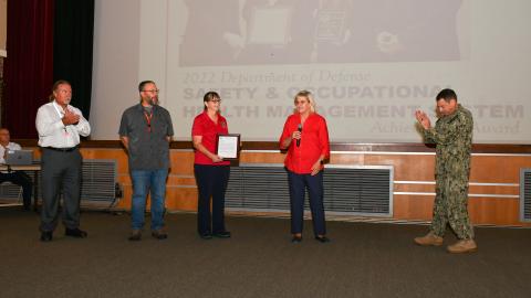 Fleet Readiness Center East (FRCE) Commanding Officer Capt. James M. Belmont and FRCE Compliance and Quality Department Head Amy Morgan congratulate members of the depot’s safety team for their recognition by the North Carolina Department of Labor Safety Awards Program. 