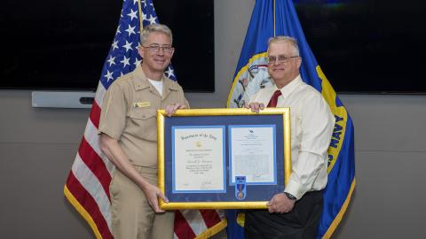 Russell Peterson, right, poses with Rear Adm. Keith Hash, NAWCWD commander, after receiving his Navy Meritorious Civilian Service Award on July 12 in Point Mugu, California. (U.S. Navy photo by Rob Grabendike)
