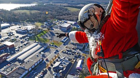 Santa waves to residents below from the skies of Southern Maryland aboard an in-flight MH-60S Seahawk helicopter.