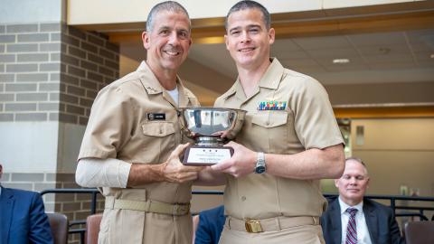 Vice Adm. Carl Chebi presents Lt. Cmdr. Zach Fisher with the NAVAIR Commander’s Speed of Capability Award