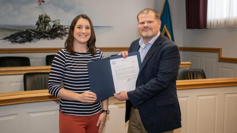 Man and woman holding paper award