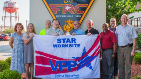  FRCE safety leaders stand with the new VPP flag.