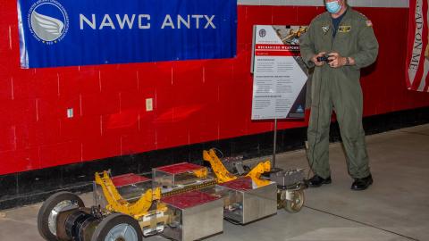 Naval Air Force Atlantic Commander, Rear Adm. John F. Meier, parks a mechanized weapons skid developed by the Naval Air Warfare Center Aircraft Division during its third annual Advanced Naval Technology Exercise at indoor site at Lakehurst, New Jersey..