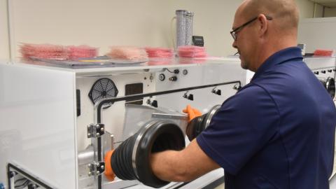 Mechanical engineer Michael Ruff using a piece of equipment in the PHS&T Lab