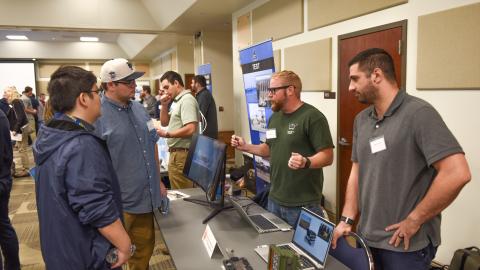 Participants visit one of the tables at Naval Air Warfare Center Aircraft Division Lakehurst's Open House