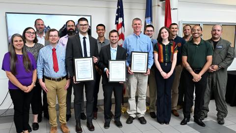 A group of professions stand with their awards 