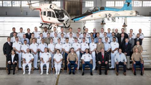 This photo shows a group shot of several graduates and Test Pilot School personnel in front of an aircraft.