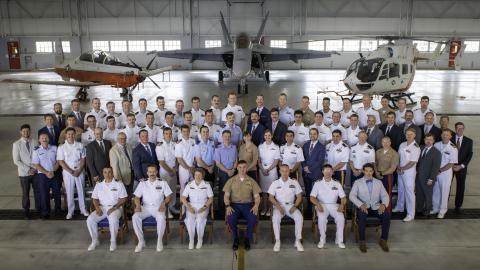 Test pilots under instruction from U.S. Naval Test Pilot School Class 166 pose for a class photo in the school's hangar.