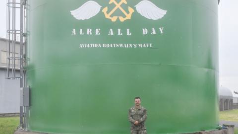 Aviation Boatswain's Mate Second Class Philip Ringgenberg stands by the water tower at Naval Air Warfare Center Aircraft Division Lakehurst