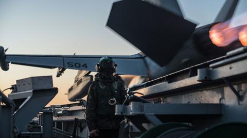 A sailor watches a catapult launch off the flight deck