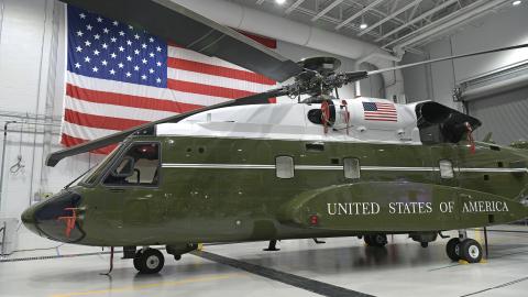 Helicopter in a hanger with the American flag behind it