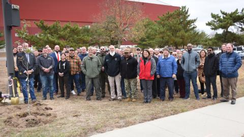 Team members from Naval Air Warfare Center Aircraft Division Lakehurst attend a tree dedication ceremony